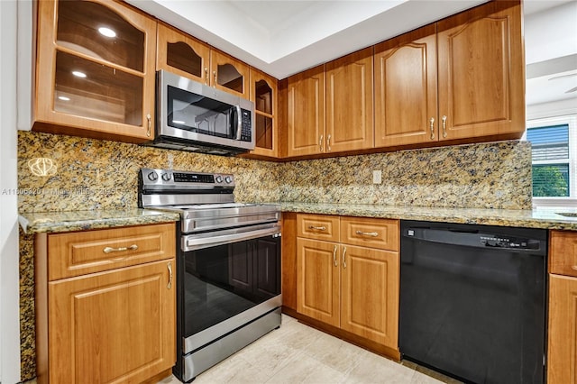 5861 NW 18th Ct, Sunrise, FL 33313 - kitchen with appliances with stainless steel finishes, light stone counters, glass insert cabinets, and tasteful backsplash