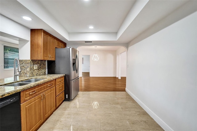 5861 NW 18th Ct, Sunrise, FL 33313 - kitchen with a sink, black dishwasher, stainless steel fridge with ice dispenser, light stone counters, and arched walkways