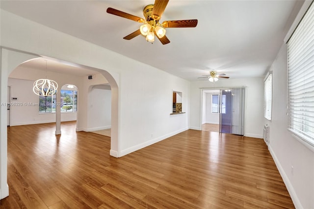 5861 NW 18th Ct, Sunrise, FL 33313 - unfurnished living room with a ceiling fan, light wood-style flooring, arched walkways, and baseboards