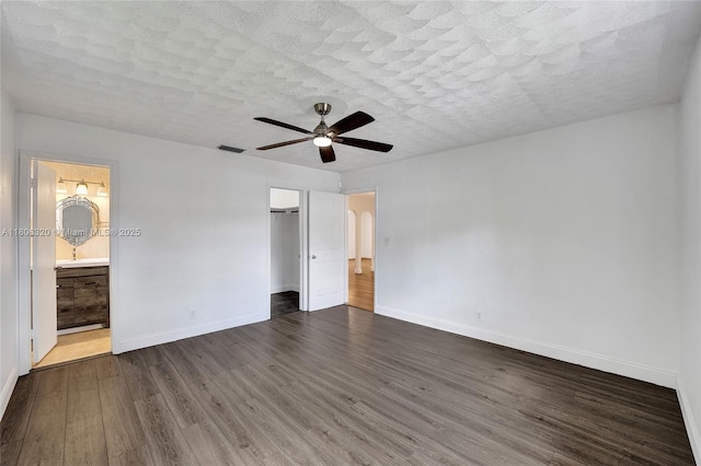 5861 NW 18th Ct, Sunrise, FL 33313 - unfurnished bedroom with dark wood finished floors, baseboards, ensuite bathroom, a closet, and a textured ceiling