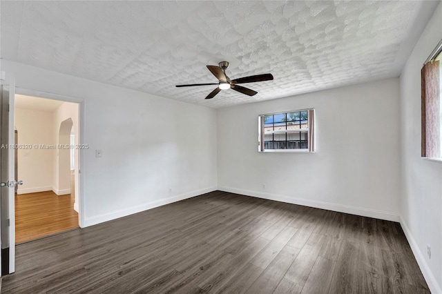 5861 NW 18th Ct, Sunrise, FL 33313 - empty room with a ceiling fan, dark wood-style flooring, baseboards, arched walkways, and a textured ceiling