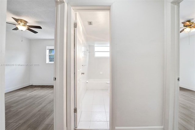 5861 NW 18th Ct, Sunrise, FL 33313 - corridor featuring plenty of natural light, baseboards, a textured ceiling, and wood finished floors