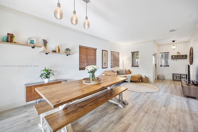 1136 NE 41st Ave, Homestead, FL 33033 - dining space featuring light wood-type flooring, crown molding, and baseboards