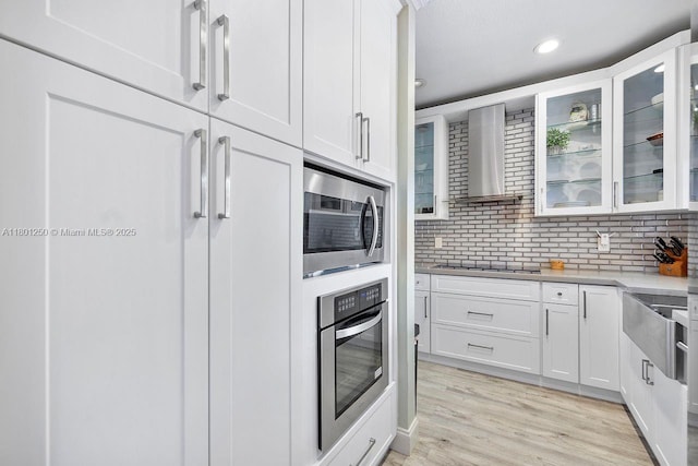 1136 NE 41st Ave, Homestead, FL 33033 - kitchen with appliances with stainless steel finishes, wall chimney exhaust hood, glass insert cabinets, white cabinetry, and recessed lighting