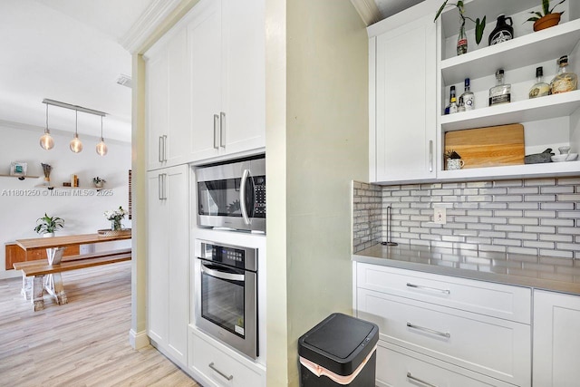 1136 NE 41st Ave, Homestead, FL 33033 - kitchen with stainless steel appliances, open shelves, backsplash, white cabinets, and light wood finished floors