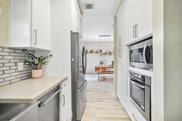 1136 NE 41st Ave, Homestead, FL 33033 - kitchen featuring stainless steel appliances, tasteful backsplash, white cabinetry, and light wood finished floors