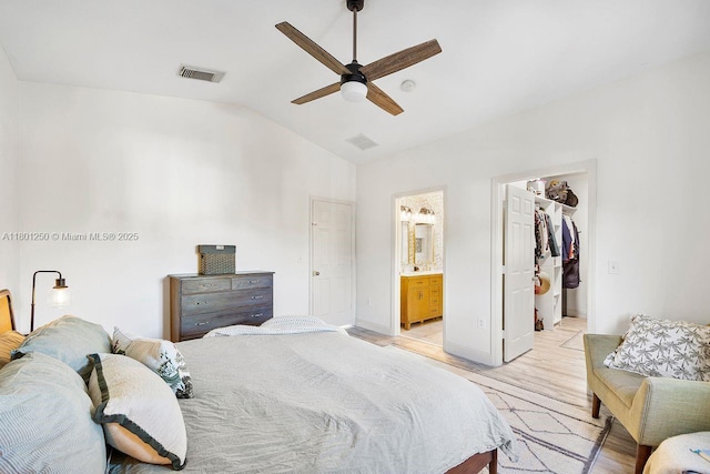 1136 NE 41st Ave, Homestead, FL 33033 - bedroom featuring light wood finished floors, lofted ceiling, connected bathroom, a walk in closet, and a ceiling fan