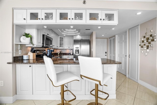 18000 N Bay Rd Unit 803, Sunny Isles Beach, FL 33160 - kitchen featuring appliances with stainless steel finishes, a peninsula, white cabinetry, dark stone counters, and recessed lighting