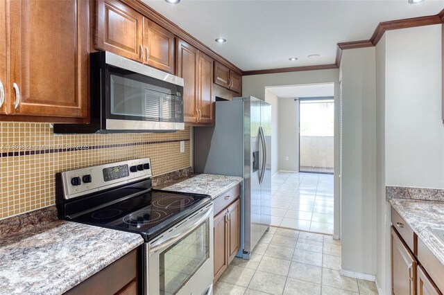 7401 NW 16th St Unit 408, Plantation, FL 33313 - kitchen with stainless steel appliances, backsplash, ornamental molding, baseboards, and light stone countertops