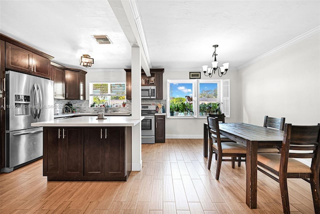 9491 SW 54th St, Miami, FL 33165 - kitchen featuring appliances with stainless steel finishes, a chandelier, light countertops, dark brown cabinets, and backsplash