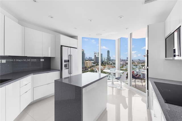 300 S Pointe Dr Unit 2005, Miami Beach, FL 33139 - kitchen with high end refrigerator, black electric stovetop, a view of skyline, modern cabinets, and a wall of windows