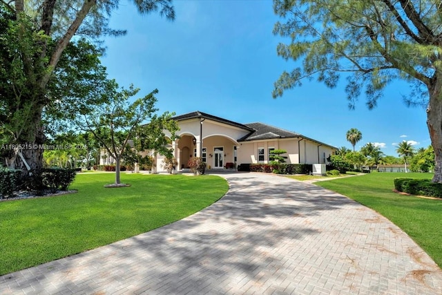 4800 SW 141st Ave, Miramar, FL 33027 - view of front of home with stucco siding, a front yard, and curved driveway
