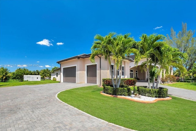 4800 SW 141st Ave, Miramar, FL 33027 - view of front of house with an attached garage, a front yard, decorative driveway, and stucco siding