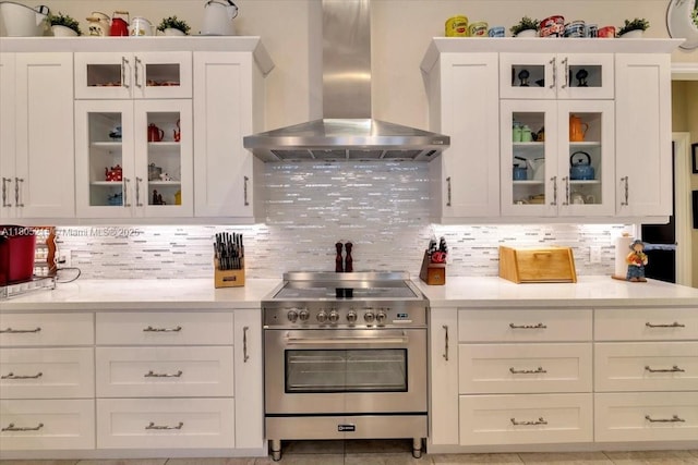 4800 SW 141st Ave, Miramar, FL 33027 - kitchen with wall chimney exhaust hood, high end stove, light countertops, white cabinets, and backsplash