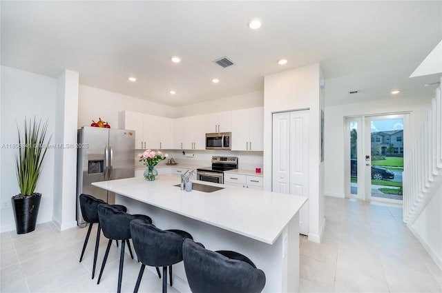 26480 SW 148th Ct Unit 26480, Homestead, FL 33032 - kitchen with stainless steel appliances, light countertops, a kitchen bar, recessed lighting, and white cabinetry