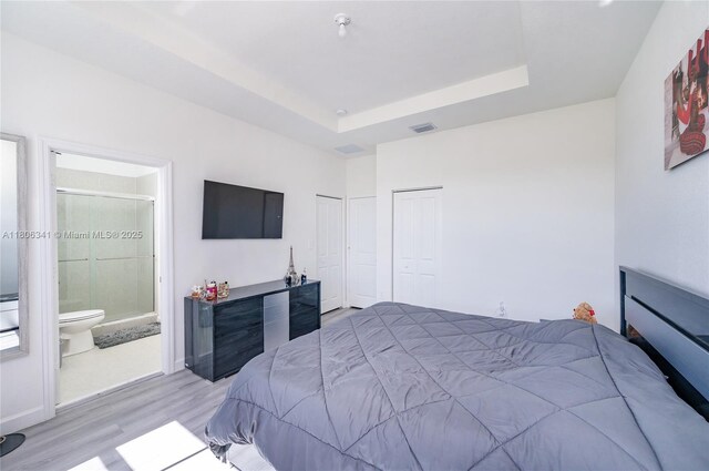 26480 SW 148th Ct Unit 26480, Homestead, FL 33032 - bedroom featuring light wood-style flooring, a tray ceiling, connected bathroom, and two closets
