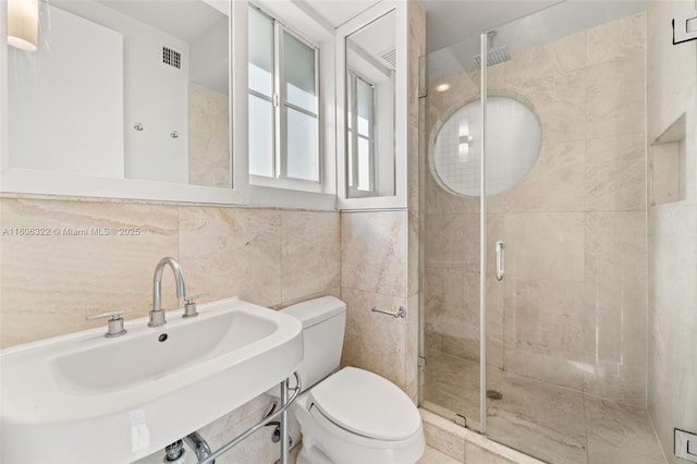 1025 Michigan Ave Unit 1C, Miami Beach, FL 33139 - bathroom with a sink, toilet, a stall shower, and tile walls
