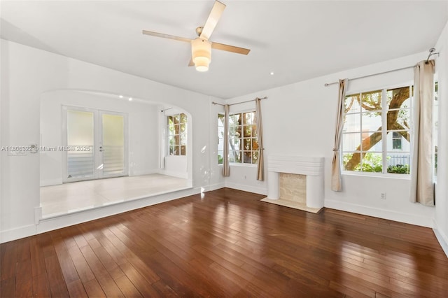 1025 Michigan Ave Unit 1C, Miami Beach, FL 33139 - unfurnished living room featuring baseboards, hardwood / wood-style floors, arched walkways, french doors, and a ceiling fan