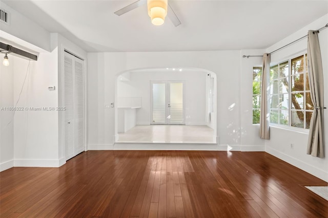 1025 Michigan Ave Unit 1C, Miami Beach, FL 33139 - unfurnished living room with arched walkways, hardwood / wood-style flooring, baseboards, ceiling fan, and french doors