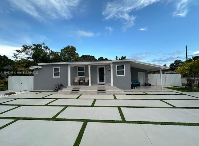 100 NE 171st Ter, Miami, FL 33162 - rear view of house with stucco siding, covered porch, concrete driveway, an attached carport, and a gate