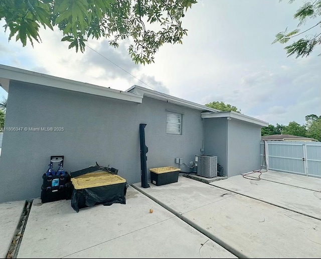 100 NE 171st Ter, Miami, FL 33162 - rear view of property featuring stucco siding, central AC, and a patio