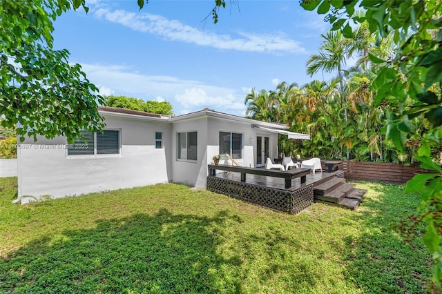 9057 Emerson Ave, Surfside, FL 33154 - rear view of property featuring stucco siding, a yard, and a wooden deck