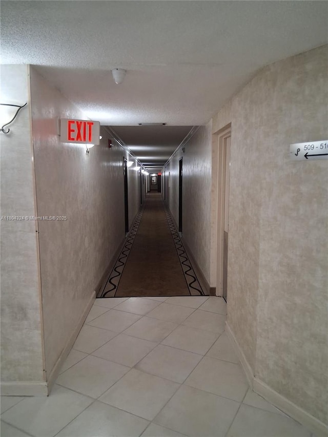 1400 Saint Charles Pl Unit 516, Pembroke Pines, FL 33026 - hall with light tile patterned flooring, baseboards, and a textured ceiling