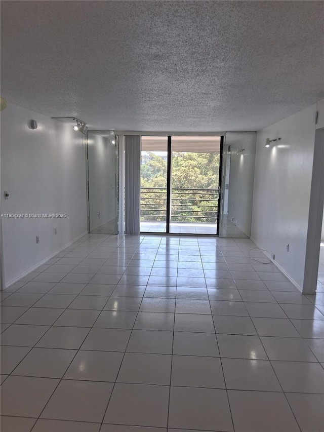 1400 Saint Charles Pl Unit 516, Pembroke Pines, FL 33026 - tiled spare room with a textured ceiling and baseboards