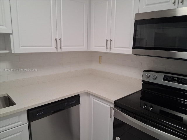 1400 Saint Charles Pl Unit 516, Pembroke Pines, FL 33026 - kitchen featuring appliances with stainless steel finishes, white cabinets, tasteful backsplash, and light stone countertops