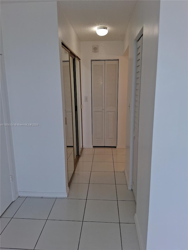 1400 Saint Charles Pl Unit 516, Pembroke Pines, FL 33026 - hall featuring light tile patterned floors, baseboards, and a textured ceiling
