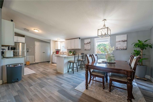 4018 Caloosa Loop, La Belle, FL 33935 - dining space featuring wood finished floors, vaulted ceiling, and baseboards