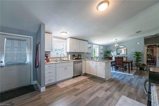 4018 Caloosa Loop, La Belle, FL 33935 - kitchen featuring stainless steel dishwasher, a sink, a peninsula, light wood-style flooring, and white cabinets