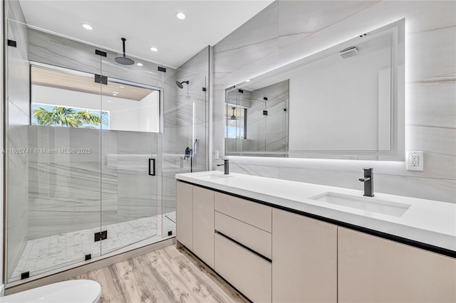 1233 NE 12th Ave Unit B, Fort Lauderdale, FL 33304 - bathroom with double vanity, a shower stall, wood finished floors, and recessed lighting