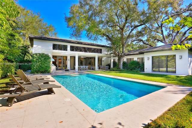 swimming pool with a patio area and a yard