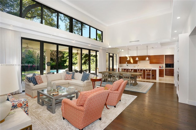 living area with wood finished floors, a high ceiling, and recessed lighting