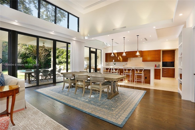dining room featuring a high ceiling, dark wood-type flooring, french doors, and recessed lighting