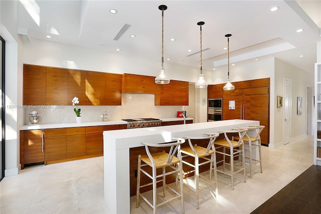 kitchen featuring appliances with stainless steel finishes, brown cabinetry, modern cabinets, tasteful backsplash, and recessed lighting