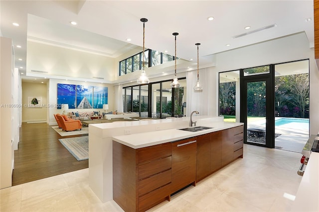 kitchen with a sink, modern cabinets, open floor plan, a spacious island, and light countertops
