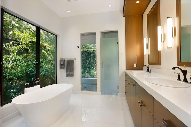 bathroom featuring tile patterned flooring, a freestanding bath, a stall shower, double vanity, and recessed lighting
