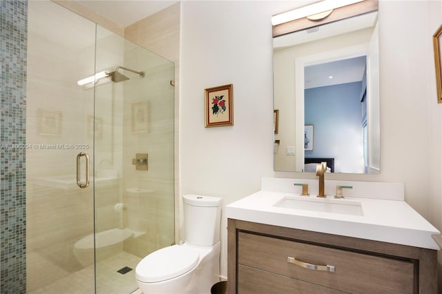 bathroom featuring a shower stall, vanity, and toilet