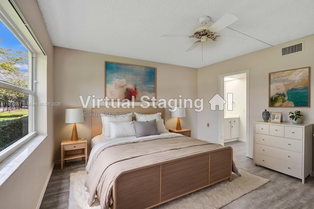 1108 Bahama Bnd Unit B1, Coconut Creek, FL 33066 - bedroom featuring baseboards, ensuite bath, light wood-type flooring, a ceiling fan, and a textured ceiling