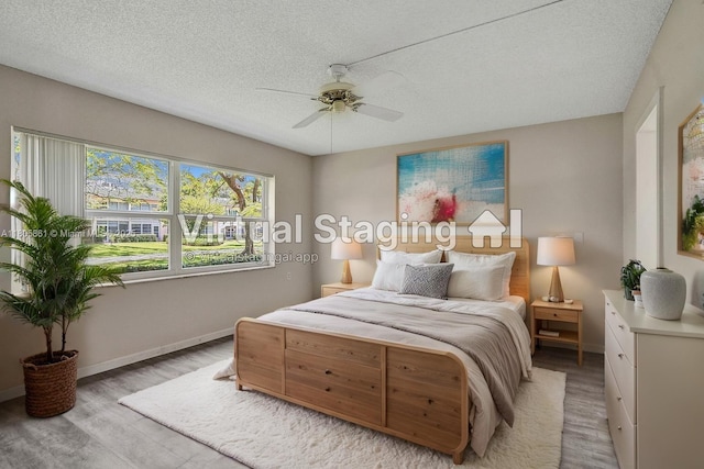 1108 Bahama Bnd Unit B1, Coconut Creek, FL 33066 - bedroom with light wood-style flooring, baseboards, a textured ceiling, and a ceiling fan