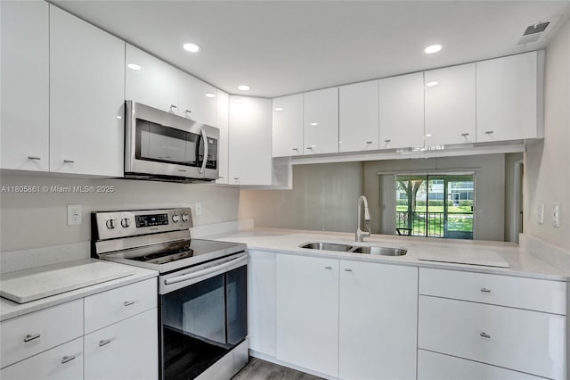 1108 Bahama Bnd Unit B1, Coconut Creek, FL 33066 - kitchen with stainless steel appliances, a sink, light countertops, white cabinetry, and recessed lighting