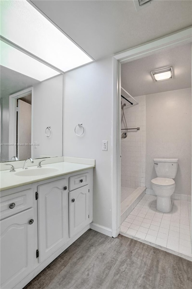 1108 Bahama Bnd Unit B1, Coconut Creek, FL 33066 - bathroom with tiled shower, wood finished floors, vanity, and toilet