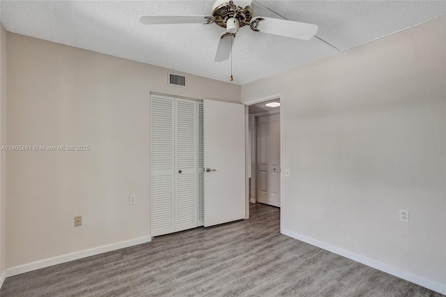 1108 Bahama Bnd Unit B1, Coconut Creek, FL 33066 - unfurnished bedroom featuring a closet, baseboards, a textured ceiling, wood finished floors, and a ceiling fan