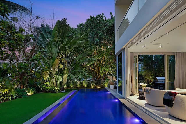 4700 N Meridian Ave, Miami Beach, FL 33140 - pool at dusk featuring an outdoor pool and a lawn
