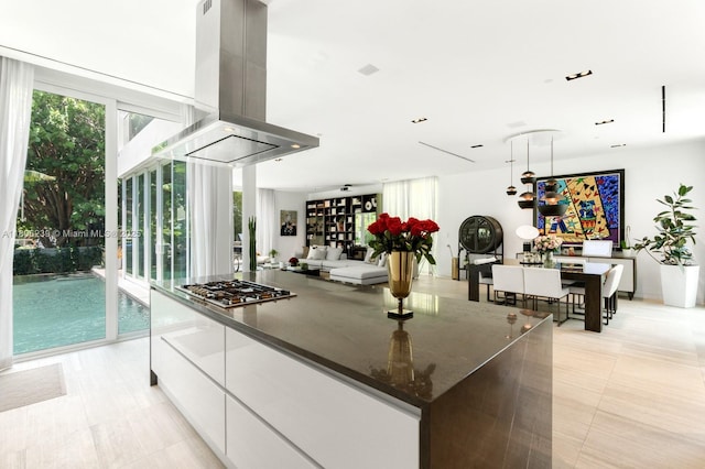 4700 N Meridian Ave, Miami Beach, FL 33140 - kitchen with island range hood, stainless steel gas stovetop, modern cabinets, white cabinets, and a kitchen island