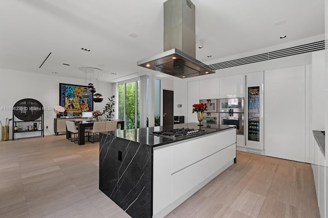 4700 N Meridian Ave, Miami Beach, FL 33140 - kitchen featuring island range hood, stainless steel gas stovetop, modern cabinets, white cabinets, and dark countertops