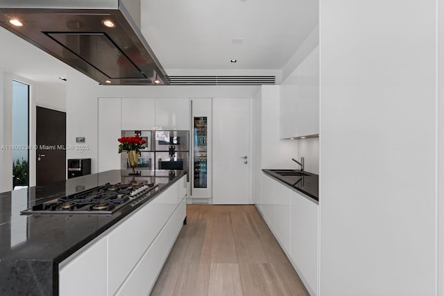 4700 N Meridian Ave, Miami Beach, FL 33140 - kitchen featuring stainless steel gas cooktop, modern cabinets, white cabinetry, light wood-type flooring, and a sink