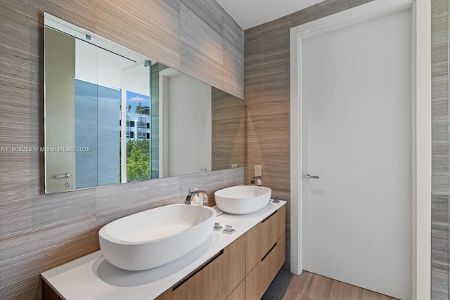 4700 N Meridian Ave, Miami Beach, FL 33140 - bathroom featuring double vanity, tile walls, and wood finished floors